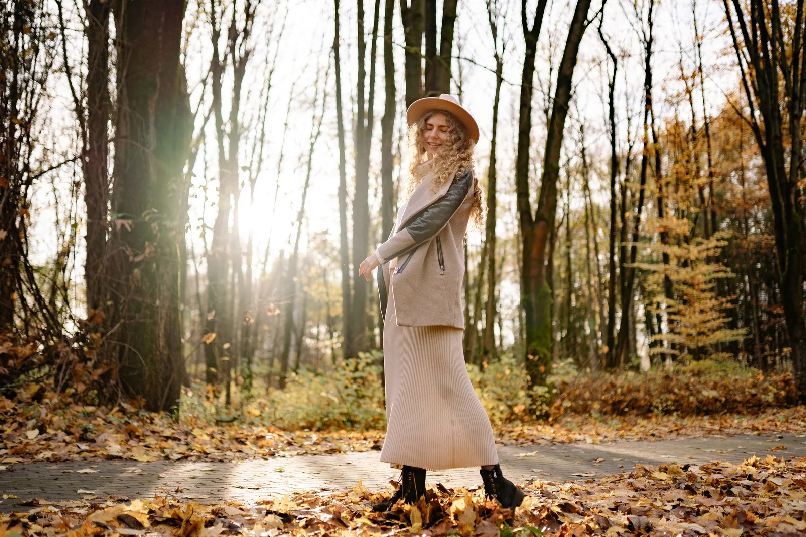 Total look nude nuancé, manteau et jupe beige dans une forêt d'automne