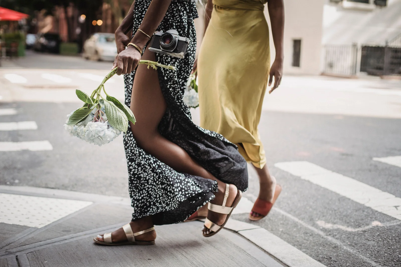 Robes midi portées avec sandales plates, jambes dégagées, silhouette allongée sans talon