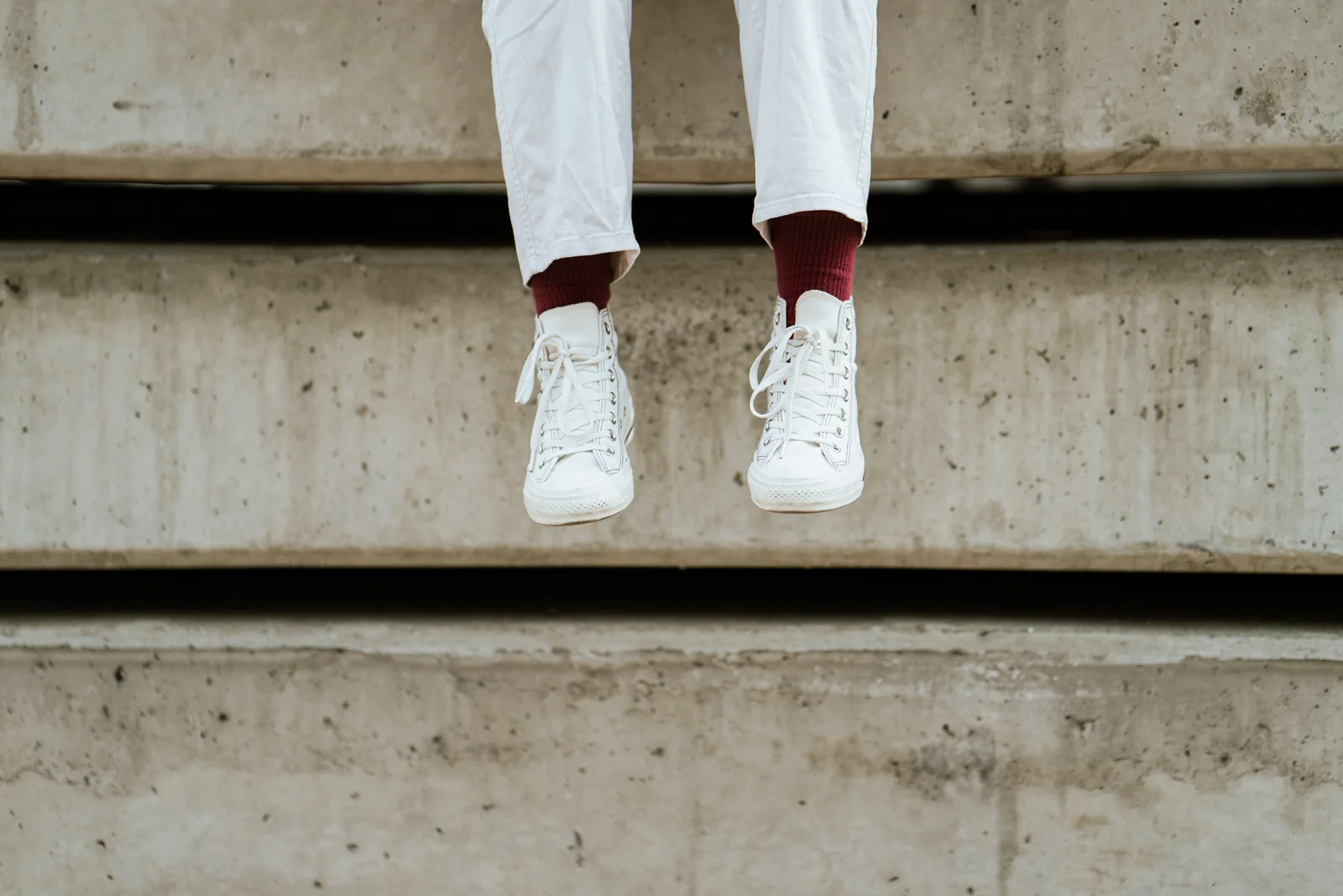 Baskets basses en cuir blanc à semelle plate portées avec un pantalon clair